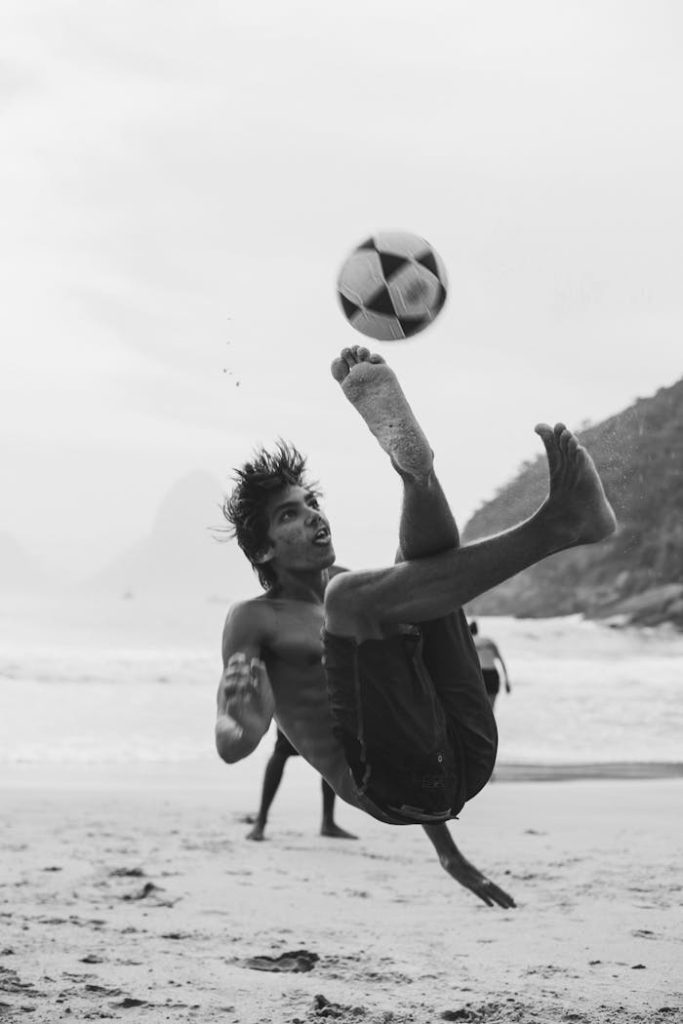 Black and white photo of a man performing a bicycle kick on Rio